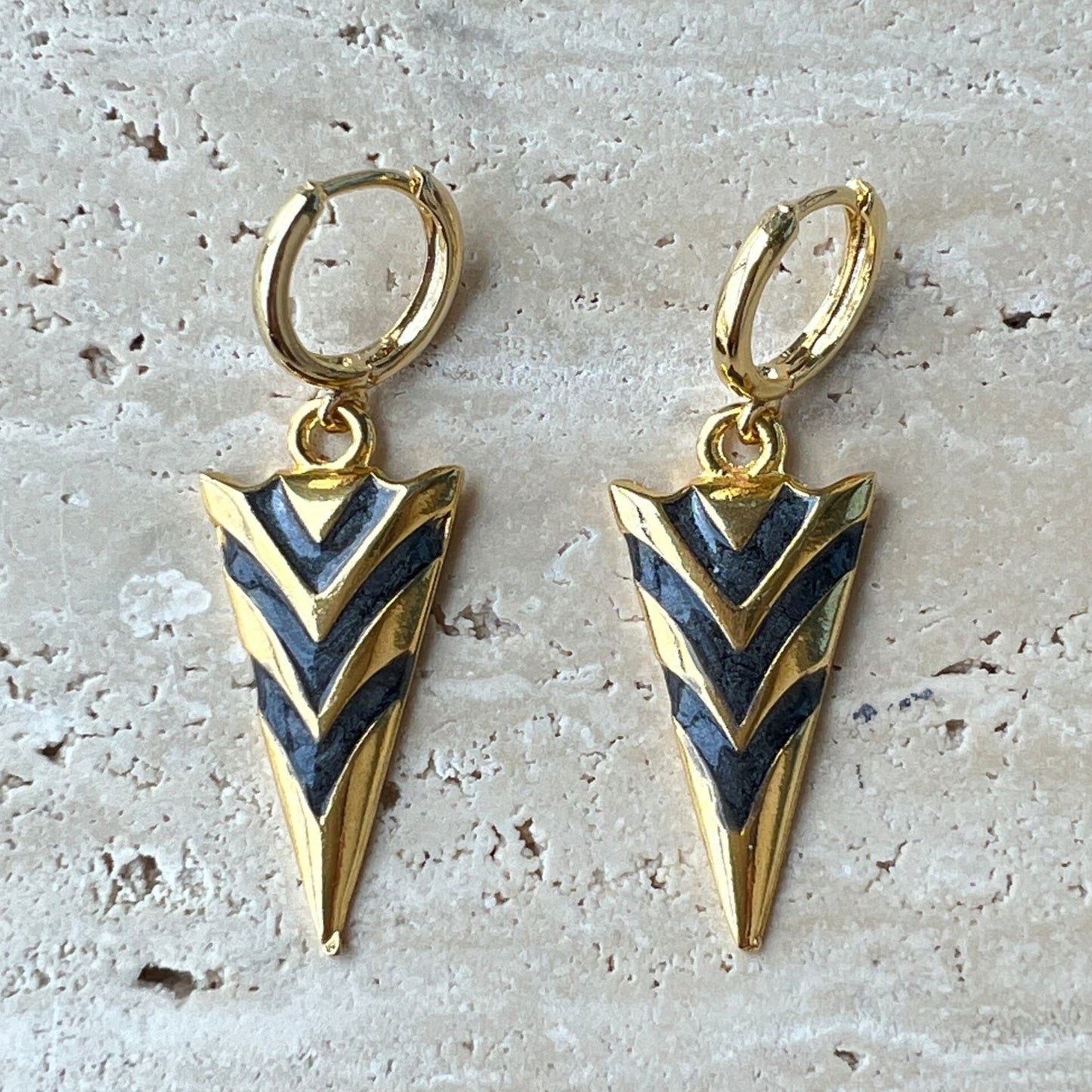 Gold arrowhead hoop earrings with black enamel chevron design