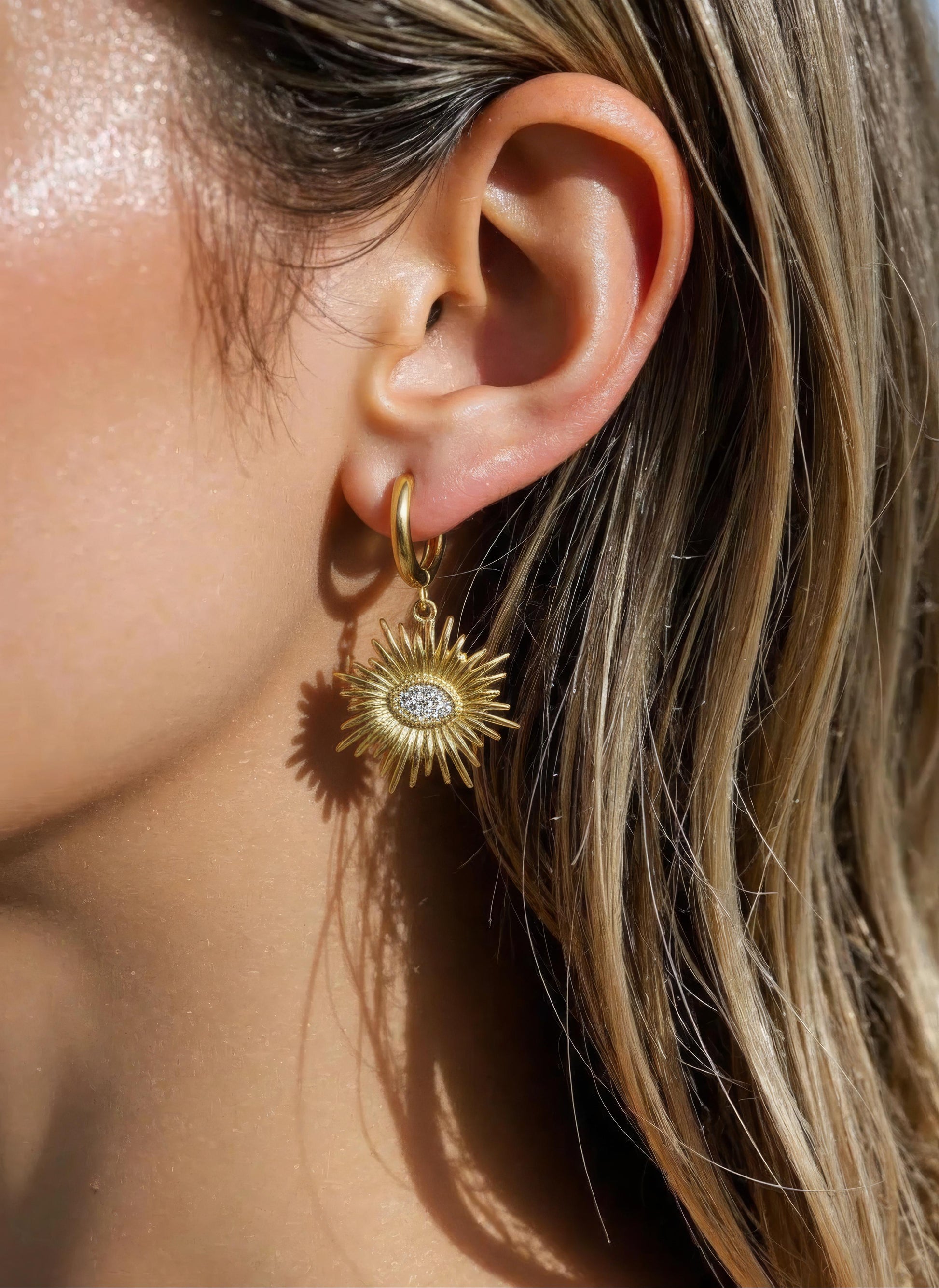 Gold sunburst earrings with zircon center on polished hoops