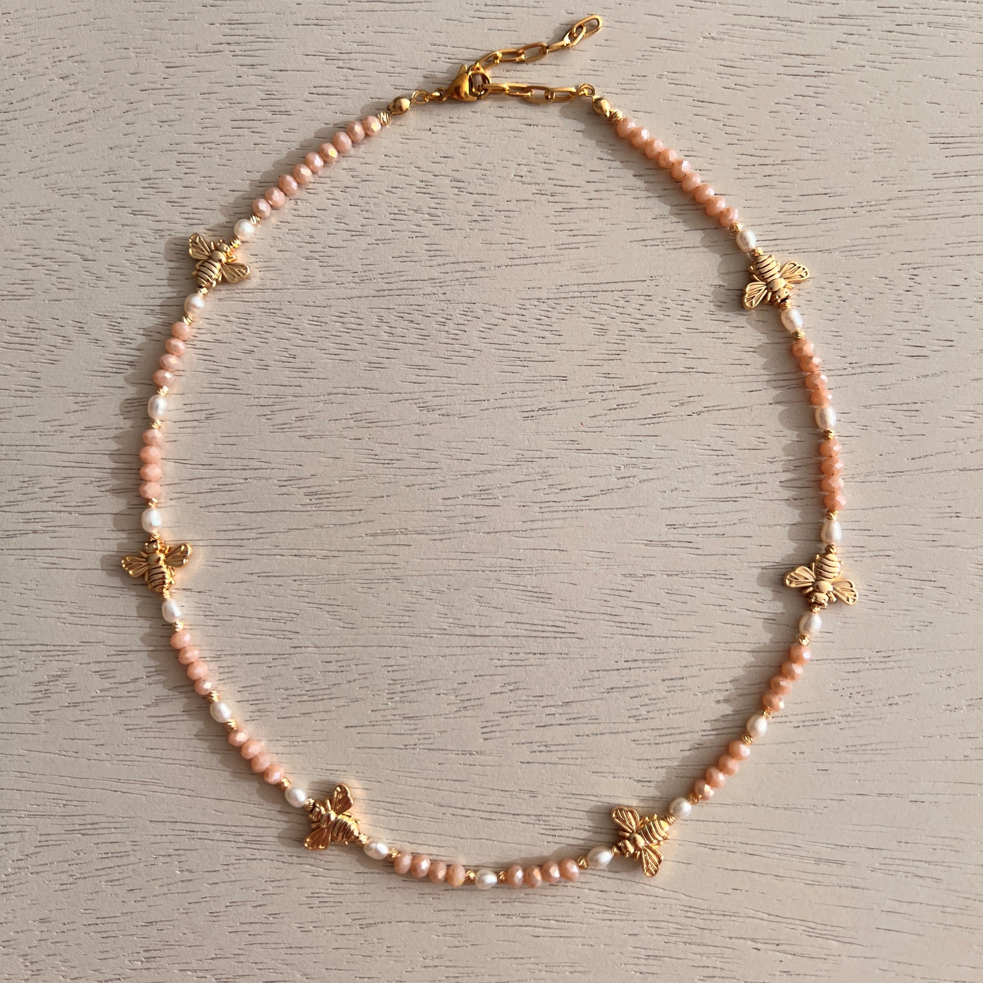 Pink crystal and freshwater pearl necklace with gold-plated bee charms