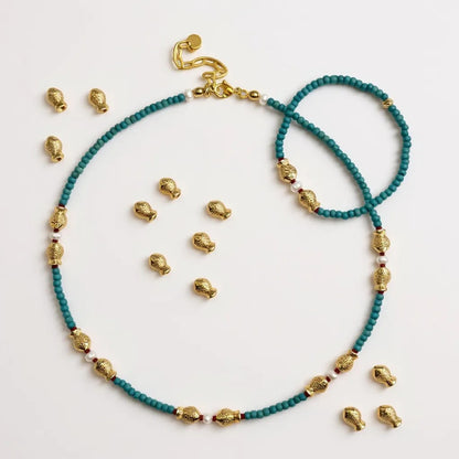 Turquoise and freshwater pearl necklace with gold-plated fish charms and red coral accents