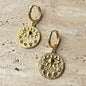 Gold hoop earrings with textured medallion, evil eye, and multicolor stones