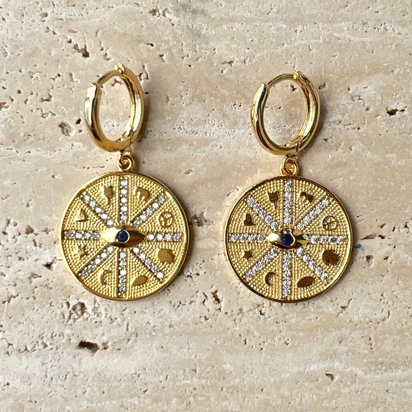 Gold compass medallion hoop earrings with black evil eye stone