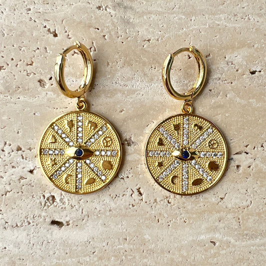 Gold compass medallion hoop earrings with black evil eye stone