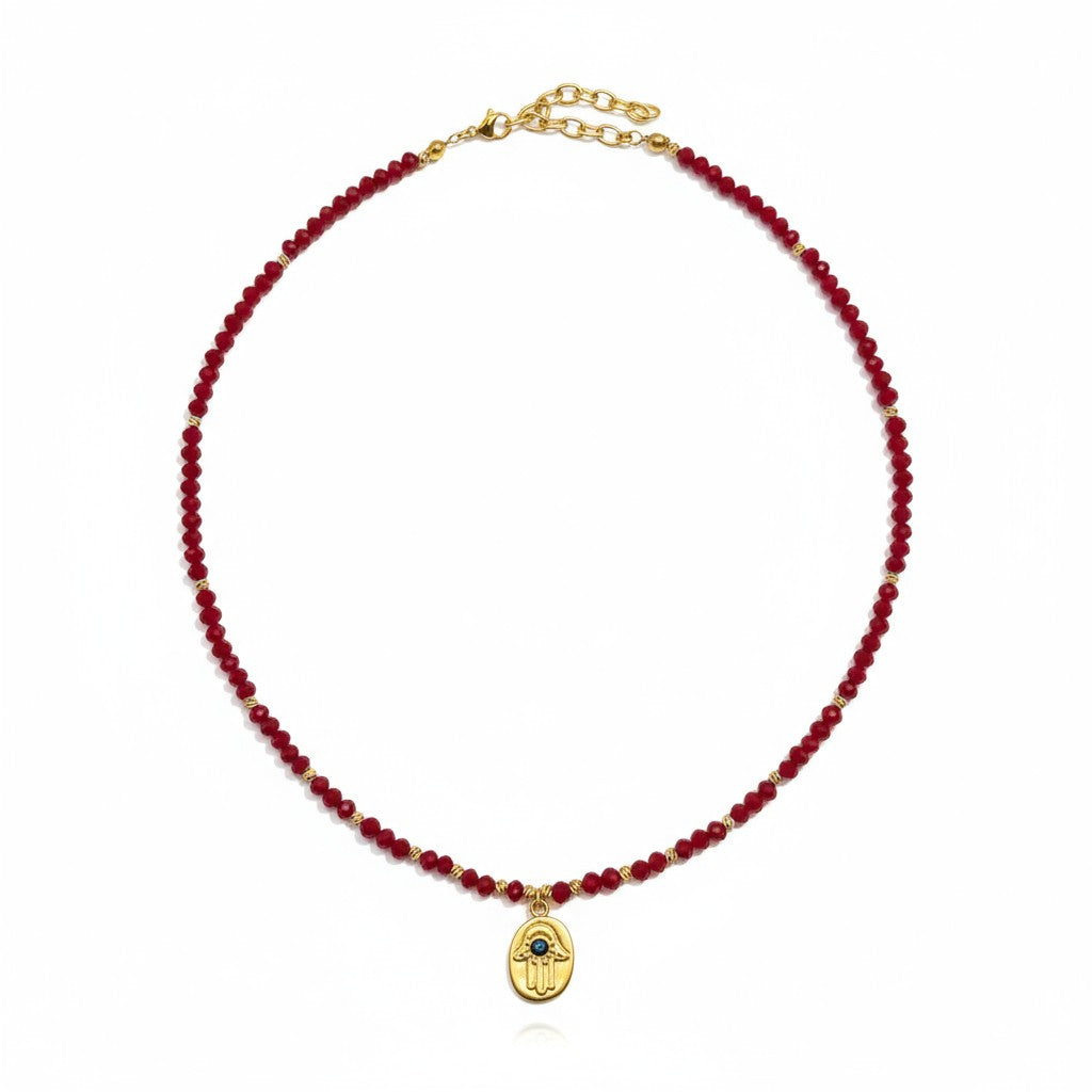 Red crystal necklace with gold-plated Hamsa charm and evil eye detailing