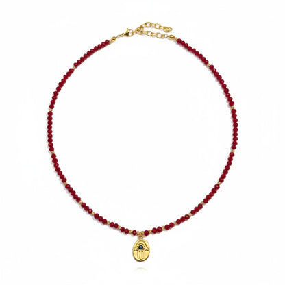 Red crystal necklace with gold-plated Hamsa charm and evil eye detailing
