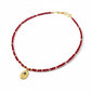 Red crystal necklace with gold-plated Hamsa charm and evil eye detailing