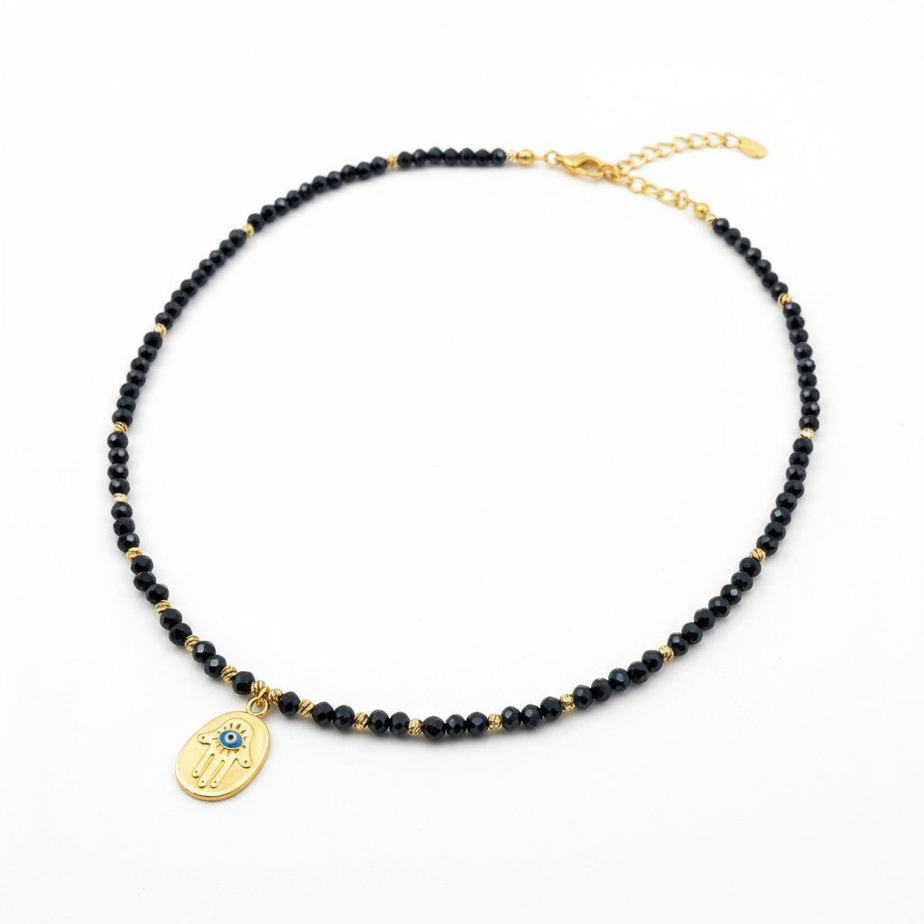 Navy crystal necklace with gold-plated Hamsa charm and blue evil eye accent