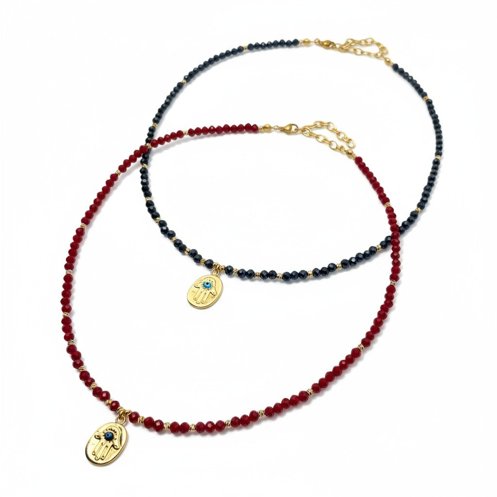 Navy crystal necklace with gold-plated Hamsa charm and blue evil eye accent